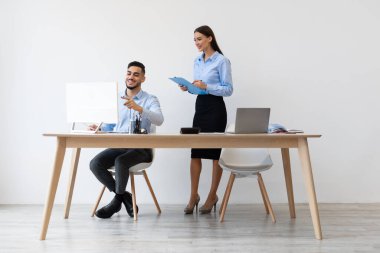 Meslektaşlar parlak bir ofiste birlikte çalışırlar. Erkek bir yönetici genç bir kadın stajyere yeni bir projeyi açıklar. Bilgisayar ekranına odaklanmış durumdalar..