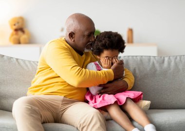 Dedesini önemseyen sıcak bir oturma odasında üzgün torununa sarılıyor. Onu zor duygularla desteklerken aynı zamanda güvende ve sevilen biri olarak görüyor..