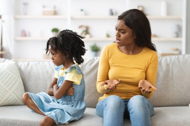 Bir anne kanepede otururken kızıyla konuşur. Kız üzgün görünüyor, kollarını kavuşturuyor, anne ise iletişim kurmaya çalışıyor..
