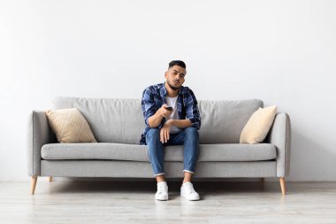 Genç bir adam evdeki bir kanepede oturur ve televizyondaki kanalları değiştirirken ilgisiz hisseder. İzleyecek eğlenceli bir şey ararken can sıkıntısı belirtileri gösteriyor..