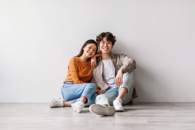 Genç bir Asyalı çift parlak bir stüdyoda yerde oturuyor, ikisi de gündelik giyinmiş. Kameraya bakarken mutlu bir şekilde gülümsüyorlar. Birlikte geçirdikleri zamanın tadını çıkarıyorlar..