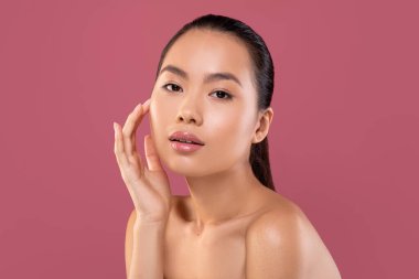 Şehvetli bir Asyalı kadın mor bir stüdyoda güzellik rutininin tadını çıkarıyor. Yüzüne özenle masaj yapar. Işıl ışıl cildine ve doğal ışıltısına dikkat çeker. Kendine özen gösterir..