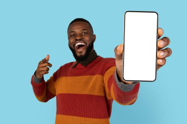 Harika bir uygulama. Neşeli genç siyah adam kamerada boş akıllı telefon gösterisi yapıyor ve onu işaret ediyor, Mutlu Afrikalı Amerikalı Erkek Uygulama ya da Mobil Teklif, Mobil Teklif, Kopya Boşluğu