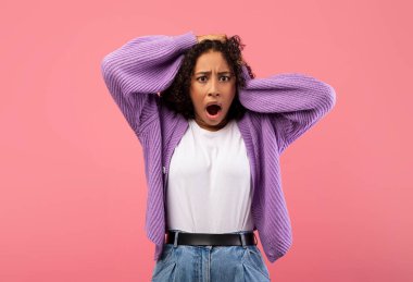 Şok olmuş Afro-Amerikalı bir kadın pembe bir stüdyo arkaplanına inanamıyor. Şaşırdığını ve şaşırdığını ifade eder. İnanılmaz bir teklif ya da olay karşısında ağzı açık kalır..