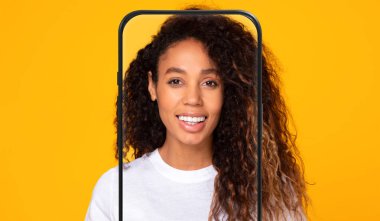 Kıvırcık saçlı neşeli bir kadın parlak sarı bir arka plana karşı poz veriyor. Kolaj, onun gülümseyen yüzünü, özelliklerini yaratıcı bir şekilde çerçevelemeyi içeriyor..