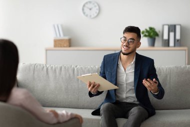 Dost canlısı bir ortadoğu danışmanı ofisinde psikoterapi muayenesi yapan bir bayan müşteriyle ilişki kurar. Tavsiye verirken atmosfer hoş karşılanıyor ve dikkatle dinliyor..