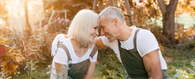 Bir çift bahçelerinde bahçıvanlık yaparken keyifli bir anı paylaşıyor. Güneş ışığı ağaçların arasından süzülür, sıcak sonbahar havasındaki ortak aktivitelerine bağlanarak mutluluklarını vurgular..