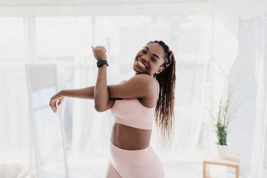 Çekici, formalı bir Afro-Amerikan kadın spor kıyafetleri giyerken kolunu uzatıyor. Kameraya gülümsüyor, tecrit sırasında sağlıklı bir yaşam tarzına olan bağlılığını gösteriyor..