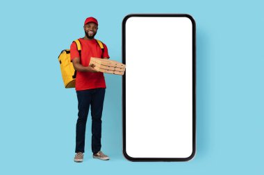 Gülümseyen Siyah Erkek Kurye, Beyaz Ekranlı Büyük Boş Smarthone 'un yanında dururken Pizza Kutuları tutuyor. Afro-Amerikan Teslimatçı Çocuk, Gıda Siparişi, Taklit, Kolaj İçin Mobil Uygulama Tavsiye Ediyor.