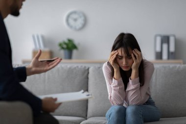 Genç bir kadın terapist ofisindeki bir kanepede oturuyor. Kafasına dokunurken gözle görülür bir şekilde sıkıntılı. Bir psikolog bu zor zamanlarda ona destek olmak için onunla konuşuyor..