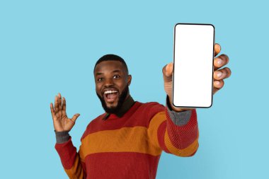 Reklam için yer. Elinde Büyük Boş Akıllı Telefon, Yeni Uygulama ya da Web Sitesi 'ne Reklam Veren Neşeli Afrikalı Amerikalı Adam Mavi Arkaplanda İzole Edilmiş, Mockup