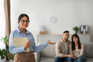 Bir evlilik danışmanı terapi seanslarından sonra mutlu bir çiftin önünde durup gülümsüyor..