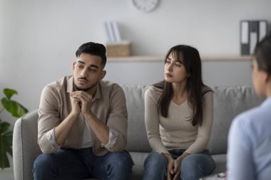 Sıkıntılı bir Arap çift terapi odasında bir kanepede oturuyor. Profesyonel bir psikologla seans yapıyorlar..