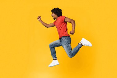 Kırmızı gömlekli genç bir adam sevinçle koşuyor, coşku ve canlılık gösteriyor. Parlak sarı arka plan, sahneye neşeli bir hava katıyor. Bu da özgürlük ve hareket hissi veriyor..