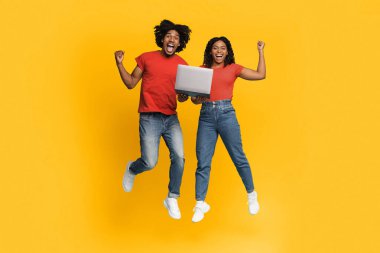 Neşeli bir çift havada zıplıyor, her ikisi de geniş bir gülümsemeyle. Aralarında bir dizüstü bilgisayar tutuyorlar, önemli bir başarıyı kutluyorlar, parlak sarı bir zemin heyecanlarını arttırıyor..