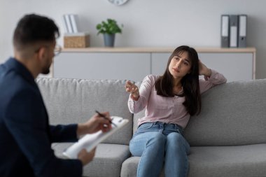 Stresli Arap kadın terapi seansı sırasında bir psikologla depresyon duygularını paylaşıyor. Mekan, tarafsız renklerle, profesyonel destek gösteren sakin bir tıp bürosu..