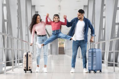 Mutlu bir aile havaalanı terminalinde el ele tutuşuyor. İki bavulları var ve bir kız, ailesinin arasına atlıyor. Hepsi gülümsüyor ve yolculukları için heyecanlı..