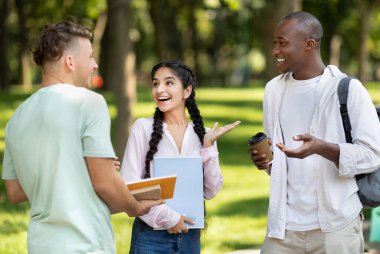 Yeşil bir parkta üç öğrenci neşeli bir tartışma yapıyorlar. Bir öğrenci kitap ve bir defter tutarken, diğeri kahvenin tadını çıkarıyor. Fikirlerini paylaşıyorlar gibi görünüyor..