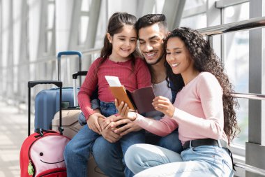 Üç kişilik bir aile havaalanında bekliyor. Birlikte oturup, bir seyahat belgesine bakarken gülümserler. Bavullar onların yanına konur ve orada mutlu bir an yaşarlar..