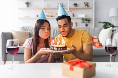 İki arkadaş doğum gününü evde kutluyor, pastayı mumlarla paylaşıyorlar. Parti şapkası takıp kırmızı şaraptan hoşlanırken etrafları şenlikli süslemelerle çevrili.