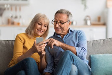 Mutlu bir son sınıf çifti oturma odasındaki koltukta oturur ve akıllı telefona bakarken bir an yaşarlar. Gülümserler ve birbirleriyle etkileşirler, eğlenirler..