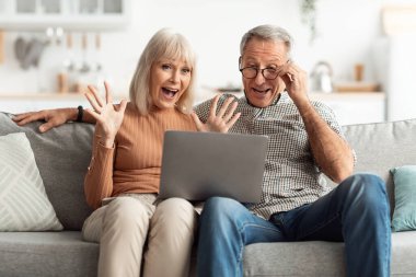 İki mutlu son sınıf öğrencisi rahat bir koltukta oturuyor ve heyecanlı bir şekilde dizüstü bilgisayarla etkileşime geçiyorlar. Teknolojiyle bağlantı kurduklarında ifadeleri neşe ve merak gösteriyor..