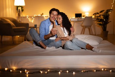 Milenyum eşleri evlerinde rahat bir akşamın tadını çıkarırken bir yatakta birlikte sevgi ve şefkat ifade ediyorlar. Sıcak yatak odaları ılık ışıklarla aydınlanıyor..