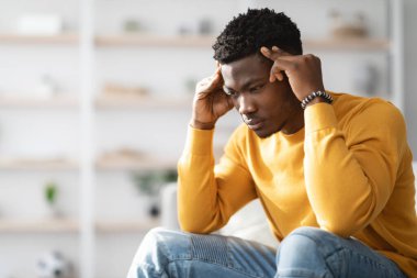 Kafasına hafifçe dokunup yere bakan neşesiz siyahi adam, Afrika kökenli Amerikan milenyumu adamı baş ağrısı çekiyor ya da iş, yan görüş, kopyalama alanı, iç mekan sorunları yaşıyor.