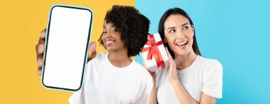 İki arkadaş neşeli bir şekilde parlak sarı ve mavi bir arkaplanda poz veriyorlar. Biri akıllı bir telefon tutarken diğeri ise bir hediye paketliyor, kutlama ve mutluluk anı yakalıyor..