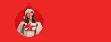 Güzel paketlenmiş bir Noel hediyesini elinde tutarken neşeli bir kadın gülümsüyor. Parlak kırmızı arka plan tatil ruhunu ve neşesini arttırır..