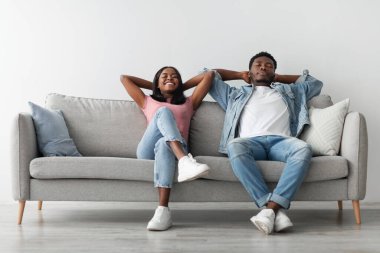 Evde takılıyorum. Sakin siyah adam ve bayan oturma odasında rahat bir kanepeye yaslanıyor. Tatmin olmuş milenyum çifti hafta sonunun keyfini çıkarıyor, hayal kuruyor ve dinleniyor.