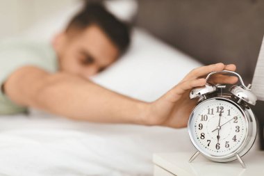 Bir adam sabahın köründe alarmını kapatmak için uzanır. Yatak odasındaki rahat ortam güne başlamayı öneriyor. Güneş ışığı pencereden süzülerek barışçıl bir atmosfer yaratır..