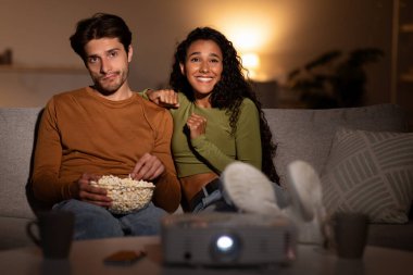 Eşler oturma odalarındaki bir kanepede birlikte oturup internetten film izlerler. Kadın heyecanlanıyor ve gülüyor, koca ise ilgisiz ve farklı film zevkleri sergiliyor..