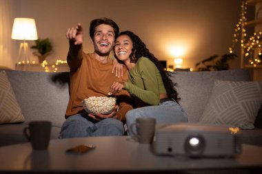 Neşeli bir çift oturma odalarındaki bir kanepede oturup internetten birlikte film izliyor. Patlamış mısırlarını paylaşıyorlar ve eğlence ve kahkahalarla dolu sıcak bir akşamın tadını çıkarıyorlar..