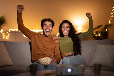 Mutlu çift kanepede oturup en sevdikleri takım için tezahürat yapıyor. Samimi oturma odalarında zaferlerini kutluyorlar, evde keyifli bir akşam geçiriyorlar..