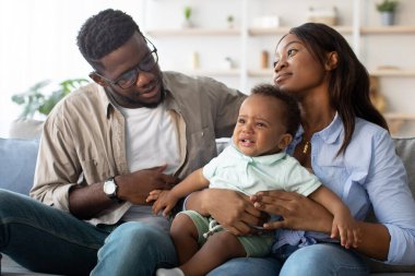 Sıcak bir oturma odasında, Afrikalı Amerikalı bir çift ağlayan oğullarını destekliyor. Anne onu nazikçe tutarken baba ona huzur sunuyor, ikisi de sinir krizini yatıştırmaya çalışıyor..