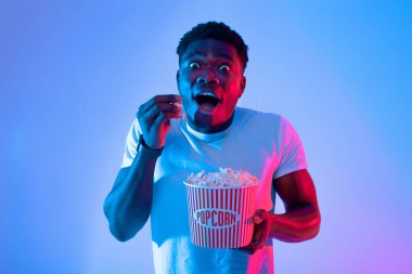 Genç bir adam çizgili kovadan patlamış mısır yerken şaşırır. Canlı mavi ve pembe ışıklarla aydınlatılıyor. Bu da bir film gecesi boyunca canlı bir atmosfer olduğunu gösteriyor..