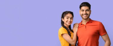 İki genç yetişkin birbirlerine yakın duruyorlar, parlak bir şekilde gülümsüyorlar. Kadının uzun örgüleri var ve erkek kırmızı bir polo gömlek giyerken sarı bir bluz giyiyor. Neşeli ve kaygısız görünüyorlar..