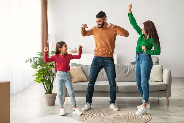 Neşeli Arap baba, karısı ve küçük kızıyla oturma odasında neşeyle dans eder. Müzik dinlerken ve eğlenirken birlikte güzel vakit geçirmekten hoşlanırlar..