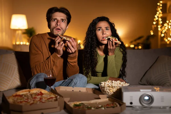 Bir çift oturma odasındaki kanepede oturur, korku filmi izlerken şoka girerler. Pizza ve patlamış mısırı seviyorlar, hafta sonu eğlenceleri için keyifli ve rahat bir ortam yaratıyorlar..