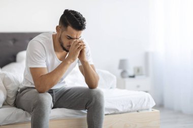 Genç bir Arap evdeki yatağında üzgün bir şekilde oturuyor. Başını ellerinin arasına gömüp sıkıntı ve umutsuzluk belirtileri gösteriyor. Oda aydınlık ve basit. Duygularını arttırıyor..