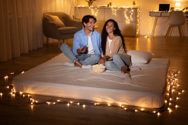 Erkek arkadaşı ve kız arkadaşı evde şiltenin üstünde film gecesinin tadını çıkarıyorlar. Patlamış mısır ve kumandayla birlikte, neşeli bir atmosferde yumuşak ışıklarla çevrili bir şekilde rahatlarlar..