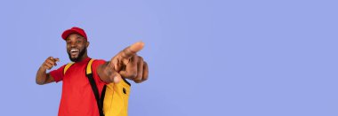 Parlak kırmızı gömlekli ve şapkalı bir adam saf mavi arka planda duruyor. O anda coşku ve pozitifliği işaret eden ve gülümseyen neşeli bir ifadesi var..