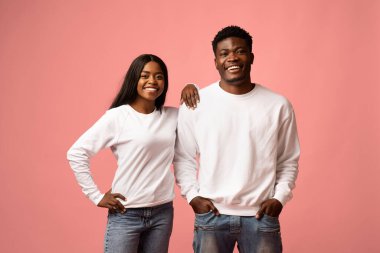 İki çekici Afro-Amerikan milenyumu bir arada, sıcak bir şekilde gülümsüyor. Genç kadın elini erkeğin omzuna koyuyor. İkisi de gündelik kıyafetler giyip bağlantılarını ve neşelerini sergiliyor..