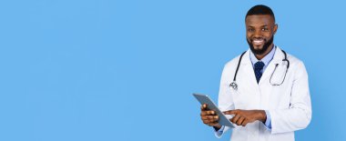 Bir doktor parlak mavi bir arka plana gülümsüyor. Beyaz önlük giyiyor ve boynunda steteskop var. Hasta muayenesi için tablet kullanırken meşgul görünüyor..