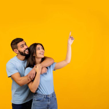 Neşeli bir ortamda, Arap bir çift kameraya bakarken sıkıca sarılır. Canlı sarı bir arka plana karşı heyecan verici bir şekilde açık bir alanı işaret ediyorlar. Bu da reklam için mükemmel bir nokta..