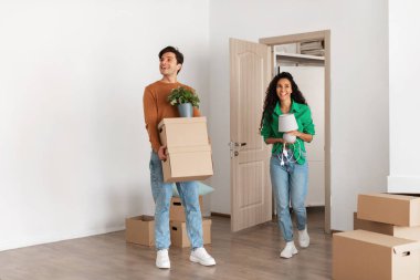 Yeni evli çift sevinçle yeni evlerine girerler. Kişisel eşyalarla dolu karton kutular taşıyorlar. Yeni alanlarında birlikte yaşamaya başlayacakları için heyecanlılar..