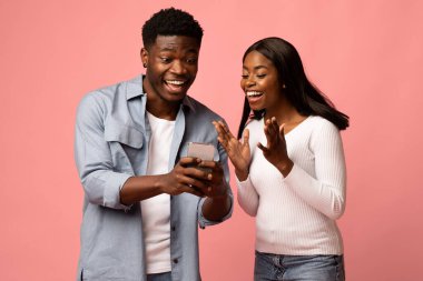 Yakışıklı bir siyah adam ve duygusal kız arkadaşı, o akıllı telefonuyla ona bir şey gösterirken büyülenirler. Parlak pembe bir stüdyoda heyecanlı görünüyorlar, neşeli bir anı paylaşıyorlar..