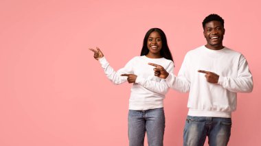 Beyaz kazak ve kot pantolon giyen neşeli bir Afro-Amerikan çifti fotokopi alanını gösterirken ışıl ışıl gülümsüyor. Canlı pembe bir stüdyo arka planına karşı kurulurlar, neşeli bir atmosfer yaratırlar..