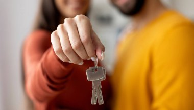 Romantik genç çiftin ev anahtarlarını tutarken, Milenyum Eşlerini Evlerine taşınırken, Kucaklarken, Gülümserken, Seçici Odaklanarak Kesilmiş Görüntü